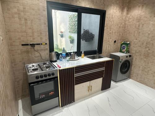 a kitchen with a stove and a sink and a window at Résidence MBK Suite in Ziguinchor