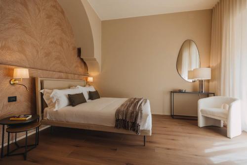 a bedroom with a large bed and a chair at CŌRA Ortigia in Syracuse