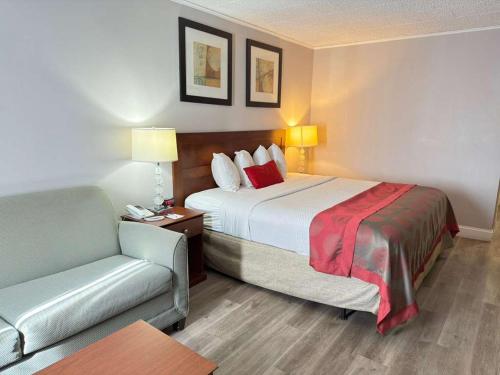 a hotel room with a bed and a couch at Ramada by Wyndham Vineland Millville Area in Vineland