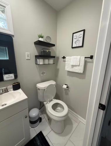 a white bathroom with a toilet and a sink at Uptown Modern Escape 4bd 2ba in Memphis