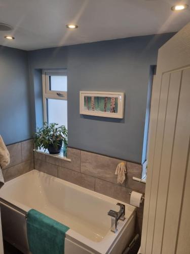 a bathroom with a bath tub and a window at 15 Kershaw Crescent in Luddenden Foot