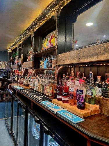 a bar with a lot of bottles of alcohol at Harbour Moon Inn in Looe