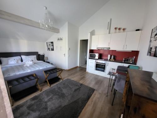 a kitchen and a living room with a table and chairs at SpiezStationLoft in Spiez