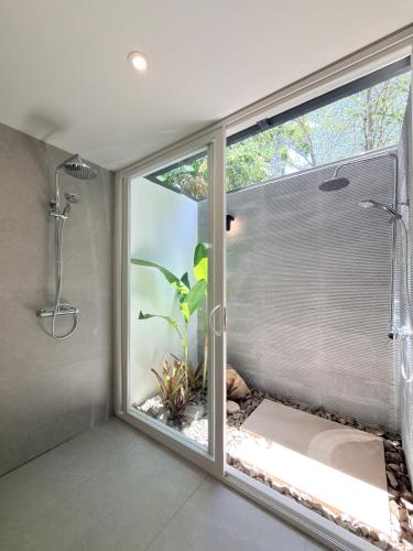a bathroom with a shower and a window with a plant at OPacifico Hotel Boutique in Naranjo