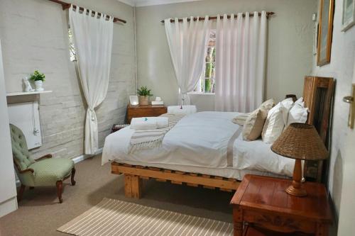 a bedroom with a large bed and a chair at FIVE on Fraser in Howick