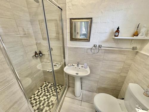 a bathroom with a shower and a sink and a toilet at FIVE on Fraser in Howick