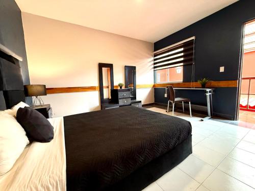 a bedroom with a bed and a desk and a chair at RMS Suites - Roma in Mexico City