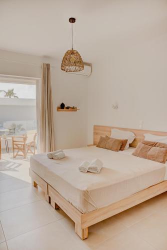 a bedroom with a large bed in a room with a balcony at Indigo Seaside Experience in Adelianos Kampos