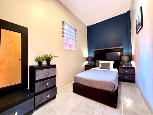 a bedroom with a bed and a dresser at RMS Suites - Roma in Mexico City