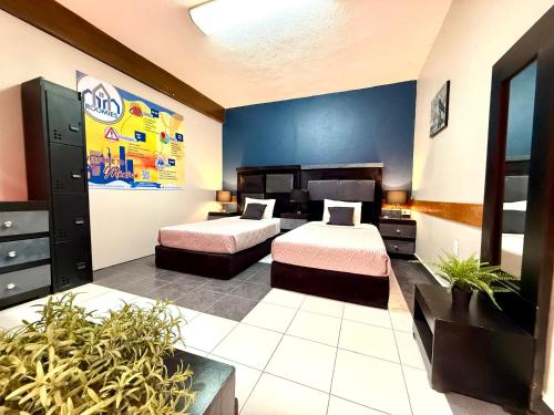 a bedroom with two beds and a blue wall at RMS Suites - Roma in Mexico City