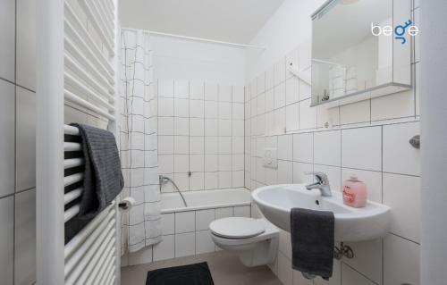 a white bathroom with a sink and a toilet at BEGE APARTMENTS ProStay in Lüdenscheid