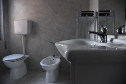 a bathroom with a sink and a toilet at Casa Luisa in Sarroch