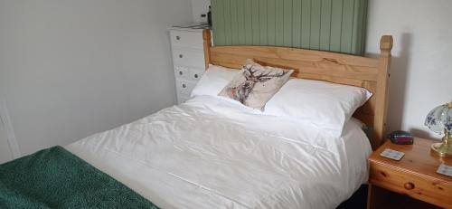 a bed with white sheets and a pillow on it at ABC Bladnoch in Newton Stewart