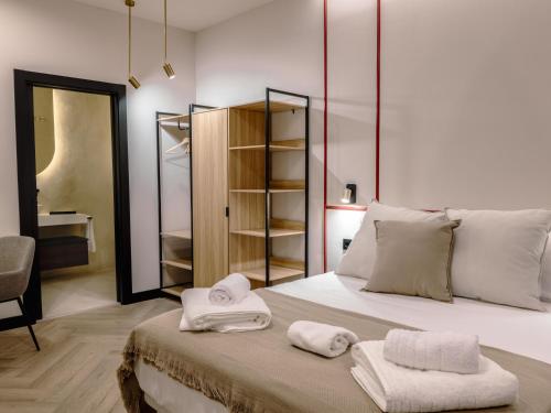 a bedroom with a bed with towels on it at Castelar Urban Suites in Badajoz
