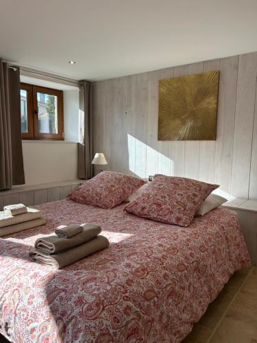 a bedroom with a large bed with two pillows at La Maison dans les Nuages in Sécheras