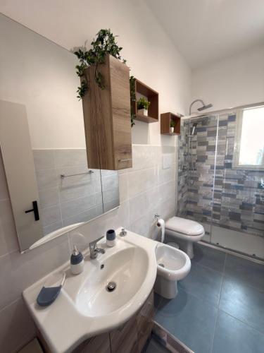 a white bathroom with a sink and a toilet at La Mya Aurora in Finale