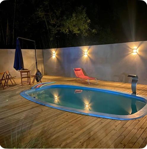 a swimming pool on a wooden deck with a chair at Suíte completa com cozinha próximo ao mar in Torres