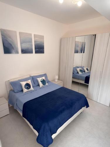 a bedroom with a blue bed and a mirror at La Mya Aurora in Finale
