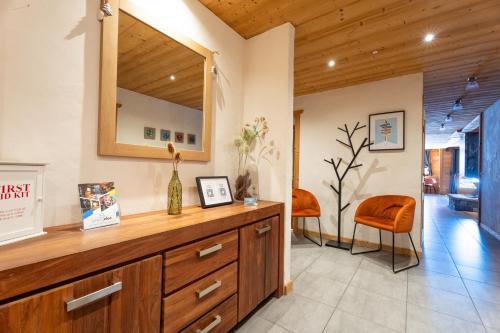 a living room with a wooden dresser and a mirror at Chalet Virolet Jacuzzi Hammam Cheminée 15 pers - MultiPass in Les Gets