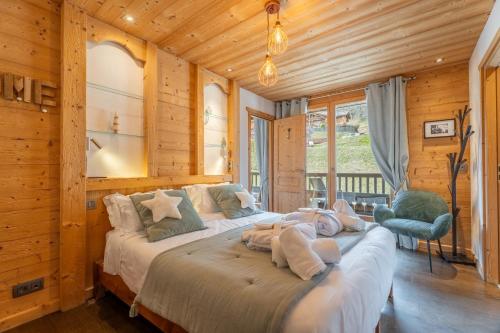 a bedroom with a large bed in a room with wooden walls at Chalet Virolet Jacuzzi Hammam Cheminée 15 pers - MultiPass in Les Gets