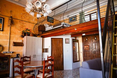 a dining room with a table and a chandelier at Ta' Battista B&B with Pool - Gozo in Xewkija