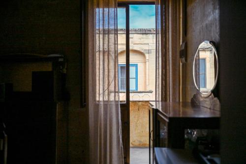 an open window with a view of a building at Ta' Battista B&B with Pool - Gozo in Xewkija