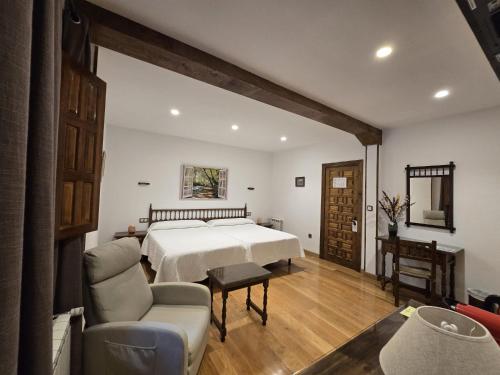 a bedroom with a bed and a chair and a table at Hosteria Picos De Europa in Potes