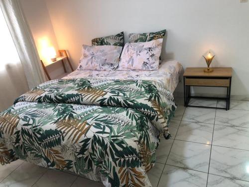 a bedroom with a bed with a green and white comforter at Studio 1 chambre in Port-Gentil