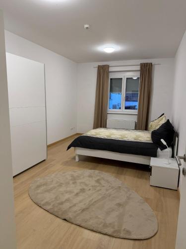 a bedroom with a bed and a large rug at Moderne zentrale Wohnung in Grosspetersdorf