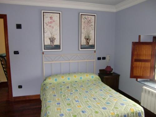- une chambre avec un lit et deux photos sur le mur dans l'établissement Aititerena, à Murueta-Orozko