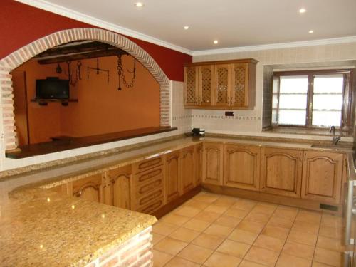 a large kitchen with wooden cabinets and a window at Aititerena in Murueta-Orozko
