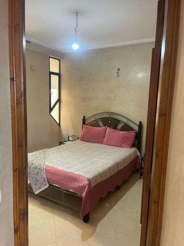 a bedroom with a bed with pink pillows at Appartement Marrakech in Marrakesh