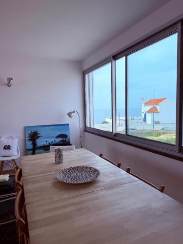 a room with a table with a view of the beach at Sunset Beach House in Zambujeira do Mar