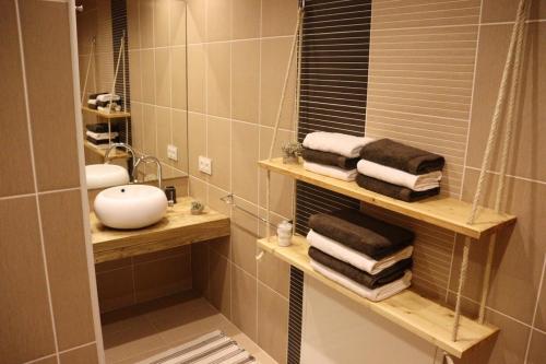 a bathroom with a sink and a mirror and towels at Sorte do Jugo - Lakeside cottage with private beach in Vieira do Minho
