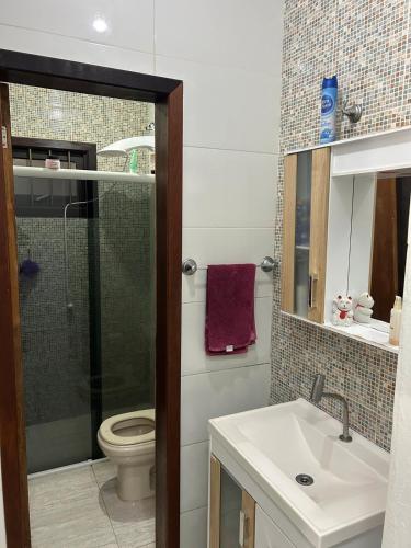 a bathroom with a shower and a sink and a toilet at Pedra Branca Retreat in Garopaba