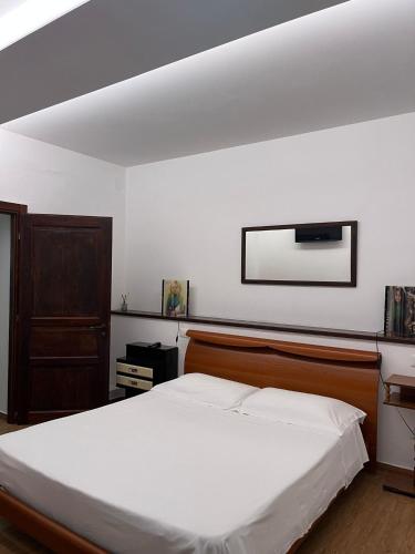 a bedroom with a large white bed and a mirror at B&B Azzurra in Pescara