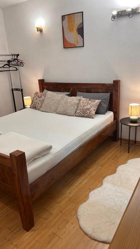a bedroom with a large bed with a wooden frame at Apartman Stone Garden in Mostar
