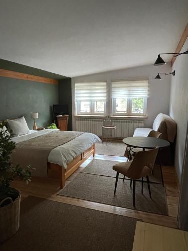 a bedroom with a bed and a table at Zielony Pokój in Ojców