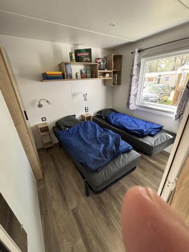a room with two beds and a window at Mobil Home 6 personnes camping 4 etoiles Bonne Anse la Palmyre in Les Mathes