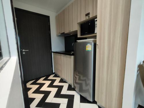a small kitchen with a refrigerator and a microwave at Venetian Signature Condominium in Jomtien Beach