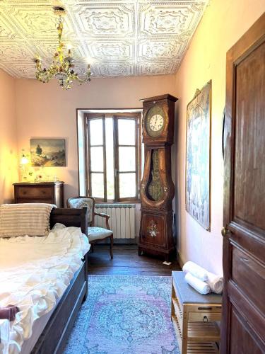 a bedroom with a bed and a grandfather clock at Charming 19th-Century BB in Saint-Martial-le-Mont, Creuse in Saint-Martial-le-Mont