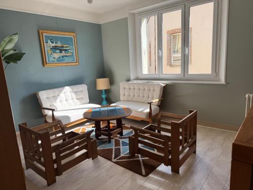 a living room with two chairs and a table at TOUCY Vintage in Toucy