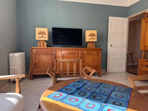 a living room with a tv and a table at TOUCY Vintage in Toucy