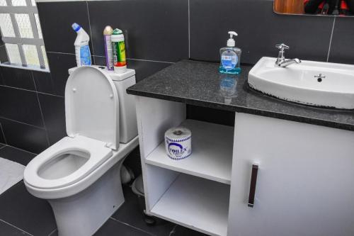 a bathroom with a white toilet and a sink at Pacificas place in Eldoret