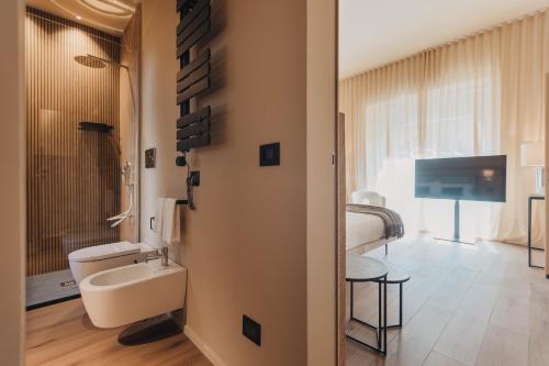 a bathroom with a toilet and a tv in a room at CŌRA Ortigia in Syracuse
