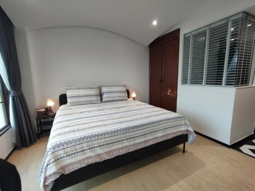 a bedroom with a large bed and two windows at Venetian Signature Condominium in Jomtien Beach