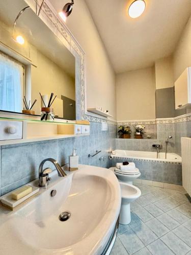 a bathroom with a sink and a toilet and a mirror at Suite Altura in Cuneo