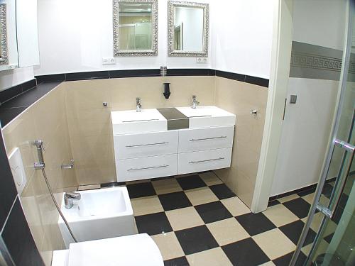a bathroom with two sinks and a mirror at Villaci Business Apartments in Leimen