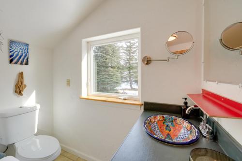 a bathroom with a toilet and a sink with a window at Bring Your Pets! Secluded Homer Escape w/ Deck in Homer
