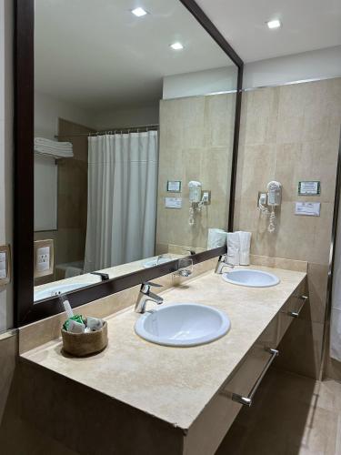 a bathroom with two sinks and a large mirror at Howard Johnson Hotel & Casino in Formosa